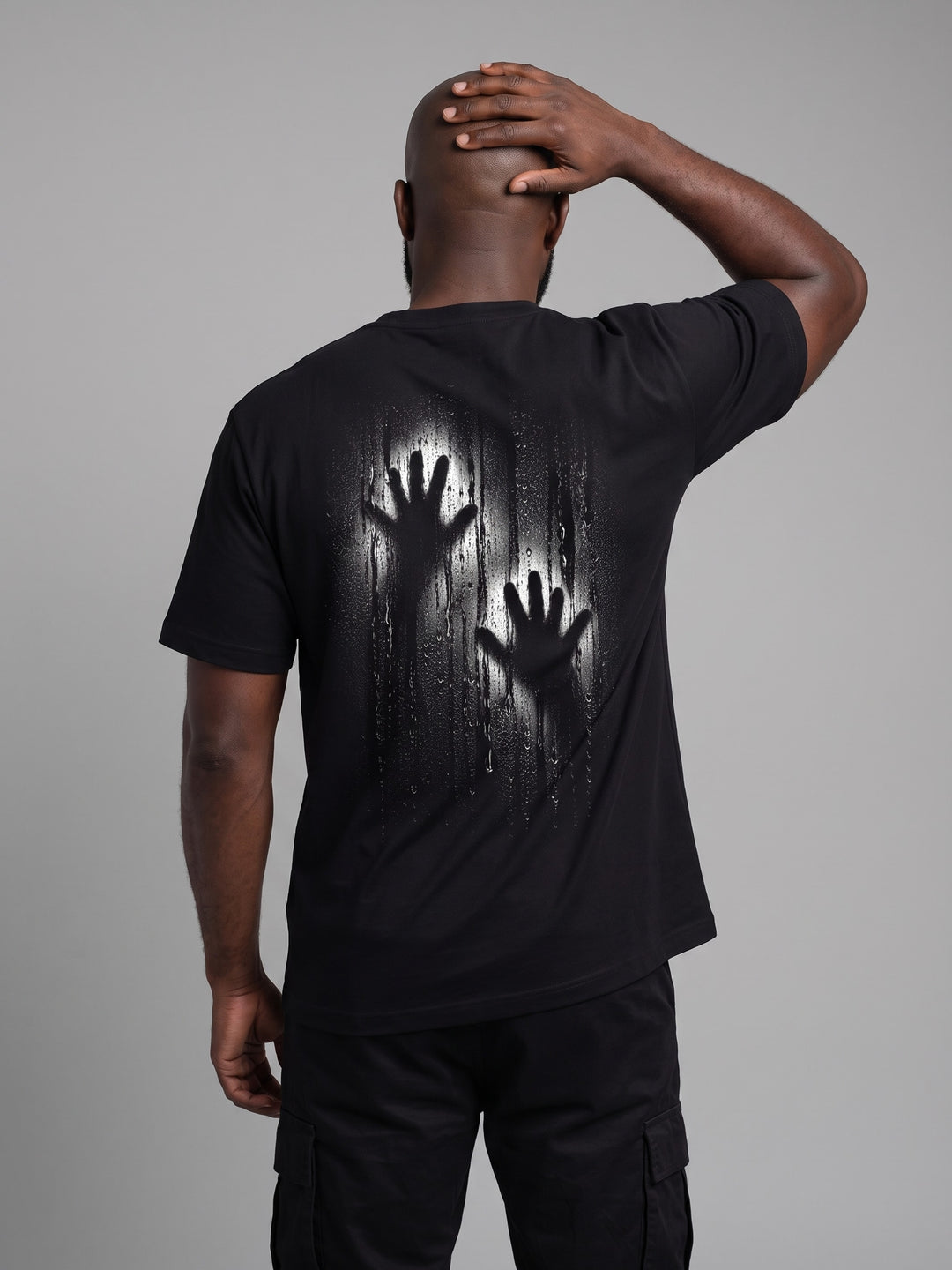 Condensation Hands Tee in black, back view on a model – NO BHVR